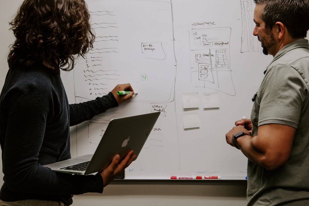 Two people in front of whiteboard showing their soft skills