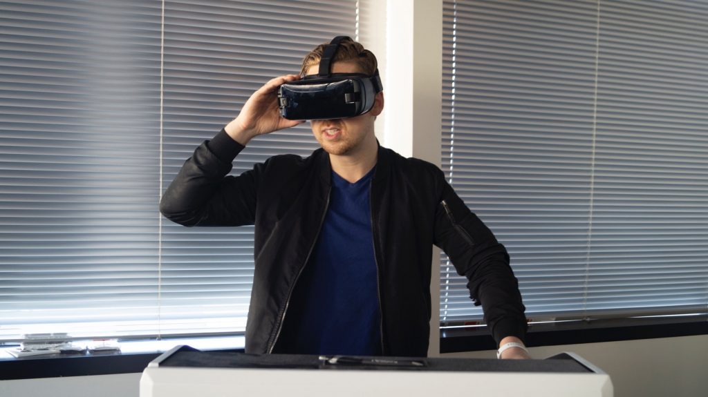 A man holding a VR headset while watching a virtual reality experience