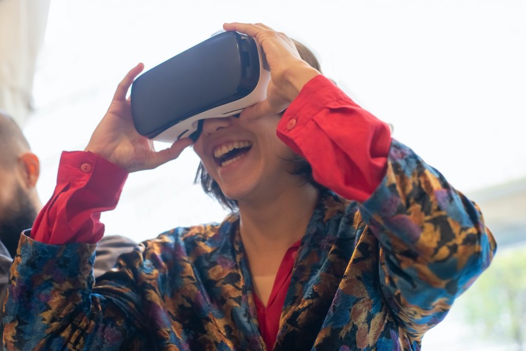 Woman using a VR headset and smiling while watching VR marketing content