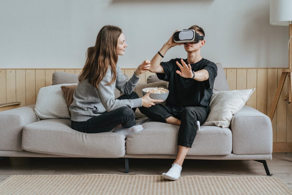 Man and a woman on a sofa using a VR headset